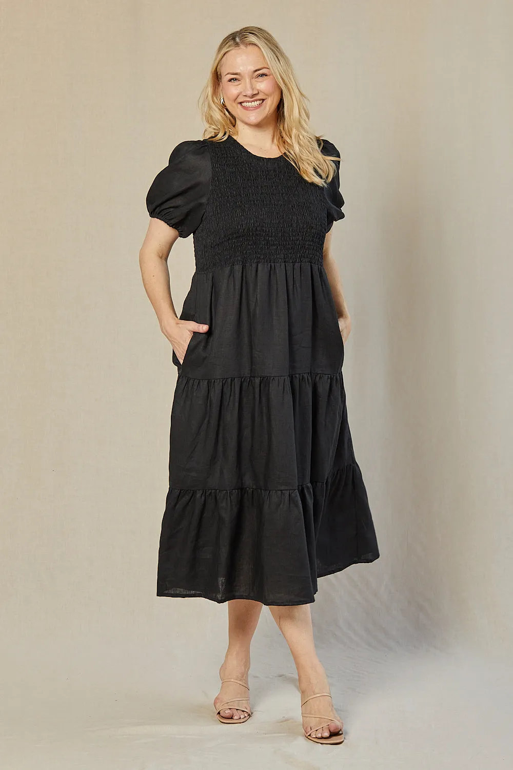 Minden Linen Shirred Short Sleeve Dress in Black The easy-to-wear design of this maxi dress ensures that you can style it effortlessly feminine grace